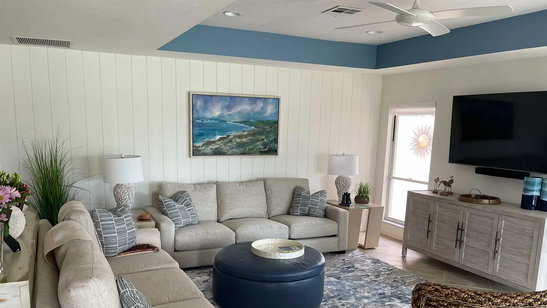Modern living room featuring white vertical shiplap and blue ceiling