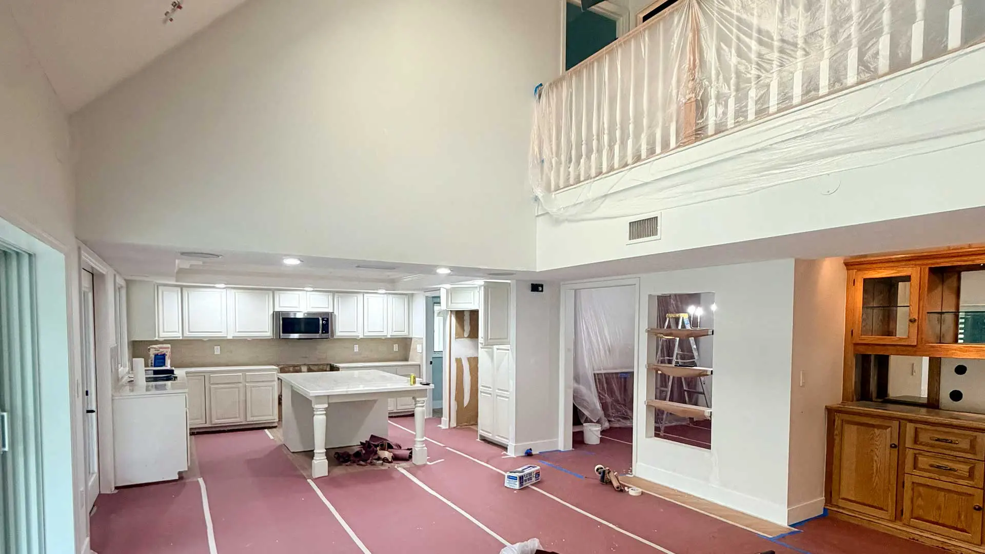 home kitchen remodeling project with covered floors and taped railings
