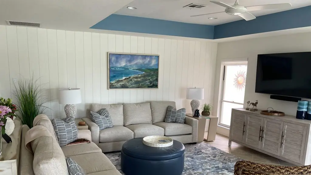 modern living room featuring white vertical shiplap and blue ceiling.