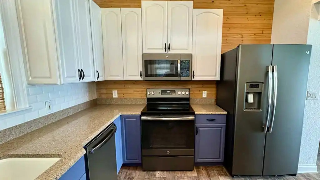 renovated kitchen featuring white upper cabinets and two tone blue lower cabinets